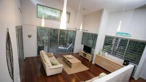 Una sala de estar moderna con sofá, mesa de centro y televisor.
