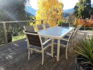Enjoy al fresco dining on the deck surrounded by lush trees and distant mountains.