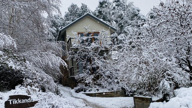 A snow-covered path leading to a house with a visible sign reading "Tikkand". - Tikkandi – Cozy Luxe Getaway in Victoria’s High Country (Merrijig)