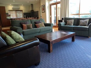Relax in this stylish living area with a large coffee table, two sofas, and a leather sofa, set against a beautiful view.