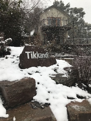 Experience the serene natural beauty of Tikkandi, surrounded by snow-covered rocks and lush shrubs.