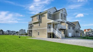 A two-story house with a front porch and a staircase leading to the second floor. - Calypso by Seaside Vacations & Sales (Greenbackville)