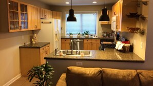 A modern kitchen with wooden cabinets, a stainless steel sink, and a central island.