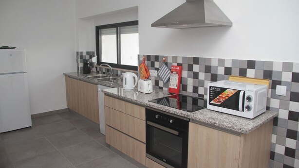 Eine moderne Küche mit Mikrowelle, Toaster, Wasserkocher und Backofen.