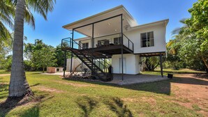 Una casa de dos pisos con un balcón y un espacio exterior cubierto.