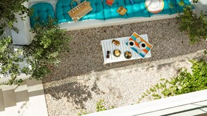 A rooftop terrace with a blue cushioned seating area, a table with a striped tablecloth, and scattered items. - New VILLA KATIA, 150 m from Sandy Beach (Chania)