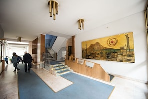 A modern interior with a staircase, a large painting, and a reception desk. - Panorama Vesuvius 1 (central) private room in apartment (Napoli)