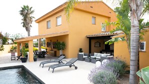 A yellow building with a swimming pool, lounge chairs, and outdoor furniture. - HOUSE IN THE EBRO DELTA, WITH WIFI, HEATED POOL, PARKING AND BARBECUE. (Deltebre)