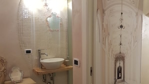 Ein Badezimmer mit einem großen Spiegel, einem Waschbecken und einem Waschtisch.