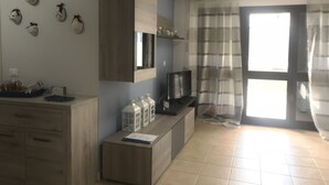 A modern kitchen with wooden cabinets, a built-in TV, and decorative wall art.