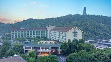 Ein Hotelkomplex mit mehreren Gebäuden, einer Pagode und üppiger Bepflanzung im Hintergrund.