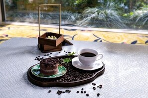 A dessert on a tray with coffee and a cup, set on a table with a patterned tablecloth. - Taixuhu Holiday Hotel (Hangzhou)