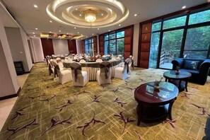 A conference room with round tables and chairs, large windows, and a carpeted floor. - Taixuhu Holiday Hotel (Hangzhou)