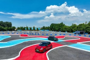 A racetrack with cars, trees, and a clear sky. - Taixuhu Holiday Hotel (Hangzhou)