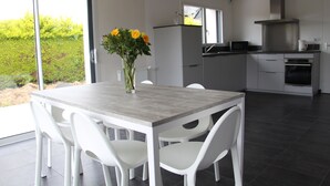 A modern kitchen with white cabinetry, a built-in oven, and a stainless steel range hood. - Vacation rentals in Beg-Meil 6 people (Fouesnant)