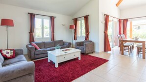 Un salon avec deux canapés, une table basse blanche et un tapis rouge.