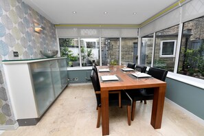 Enjoy meals in this dining area with a table for four, glass-fronted cabinet, and large window.