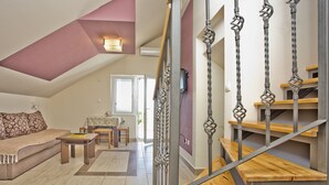 A spacious living area with a high ceiling, a staircase with metal balusters, and a view of the outdoors through a door. - Spacious villa with an outdoor swimming pool (Ðuraševici)
