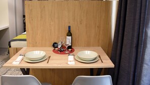 Une table à manger dressée avec des assiettes, des couverts, une bouteille de vin et des verres.