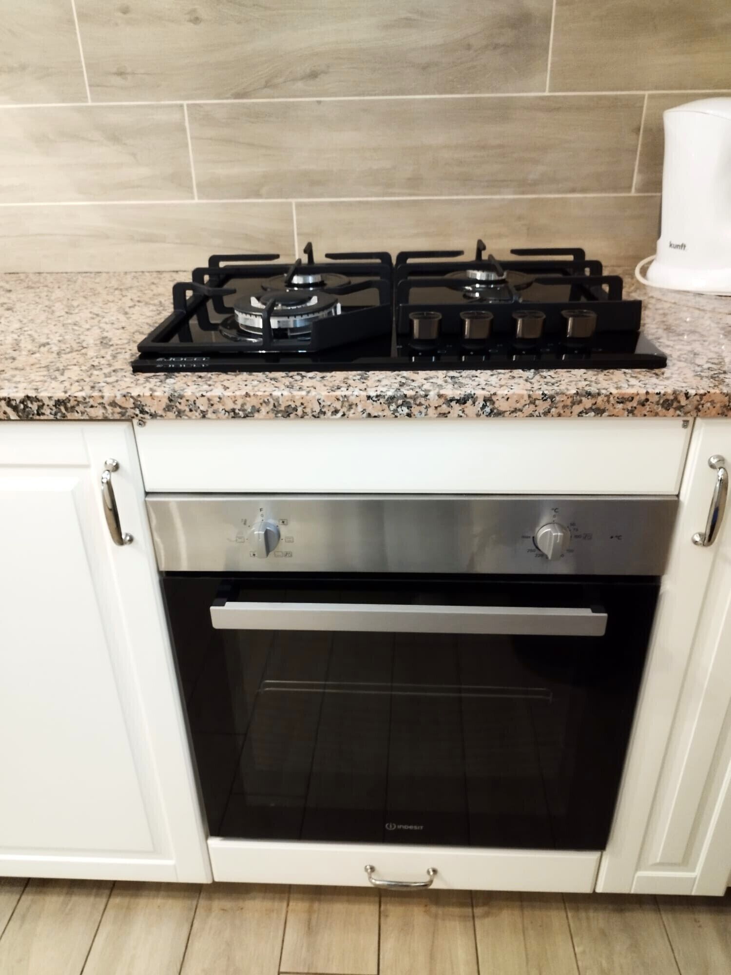 A kitchen with a gas stove, oven, and granite countertop.