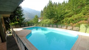 A swimming pool with a view of mountains and trees.