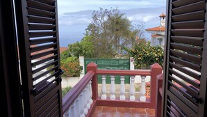 A view from a balcony with a railing, a tiled floor, and a green fence in the background. - Villa with views to the sea and the Teide and the Island of La Palma  (Tenerife)