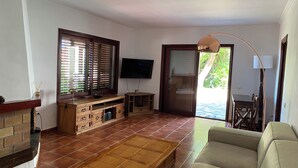 A living room with a TV, wooden entertainment unit, sofa, and a fireplace. - Villa with views to the sea and the Teide and the Island of La Palma  (Tenerife)