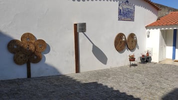 Traditional inn with a charming entrance, decorative metal flower wall art, and a tiled roof.