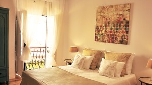 Ein Schlafzimmer mit einem Bett, zwei Nachttischen, einem Fenster mit Vorhängen und einem Wandbild.