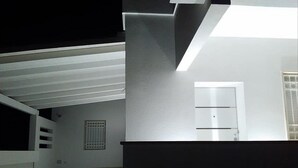 Una escalera que lleva a un rellano con una puerta y una ventana.