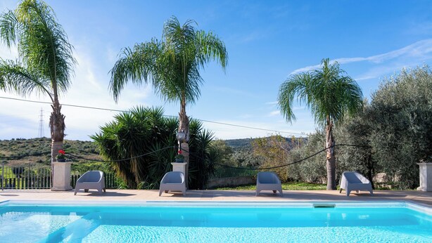 A swimming pool with lounge chairs and palm trees. - Ninfa Charming Accomodation in the Eastern Coast (Floridia)
