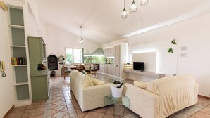 A spacious living area with a sofa set, a coffee table, and a television. - Ninfa Charming Accomodation in the Eastern Coast (Floridia)