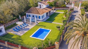 Il s’agit d’une propriété résidentielle dotée d’une piscine, d’une terrasse avec des chaises longues et d’une pelouse bien entretenue.