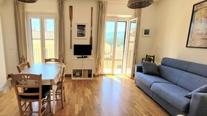 Amplia sala de estar con mesa de comedor, sofá y televisor.