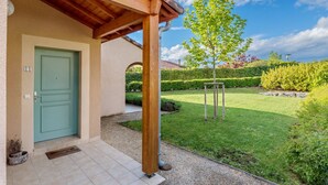 A building with a green door, a covered porch, and a well-maintained garden with a tree and hedges. - Delightful villa for 4 people at Domaine Les Rives de l'Ardèche (Vallon-Pont-d'Arc)