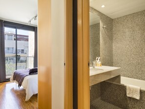 Ein modernes Badezimmer mit einer Granittafel, einer Duschkabine aus Glas und einem großen Spiegel.