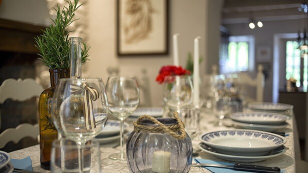 A dining table set with clear glassware, a candle, and a decorative jar. - Villa in Poggioni with 5 bedrooms sleeps 10 (Poggioni)