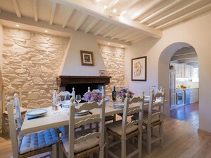 A dining area with a stone wall, a fireplace, and a view into the kitchen. - Villa in Poggioni with 5 bedrooms sleeps 10 (Poggioni)