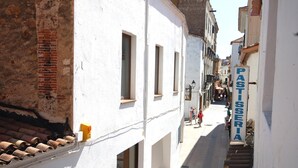 A narrow street with white buildings, a visible sign for 'PASTISERIA', and a staircase leading down. - COZY APARTMENT 70 m. from THE BEACH in TOSSA (Tossa de Mar)
