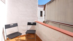 A small outdoor balcony with two black chairs and a white wall. - COZY APARTMENT 70 m. from THE BEACH in TOSSA (Tossa de Mar)