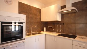 A modern kitchen with white cabinets, a built-in oven, and a stainless steel sink. - COZY APARTMENT 70 m. from THE BEACH in TOSSA (Tossa de Mar)