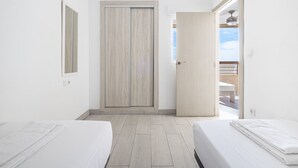 A hotel room with two beds, a wooden door, and a balcony with a view. - Acuarium 3-19-E (Benidorm)