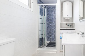 A modern bathroom with a white sink, a toilet, and a shower area with a glass door. - Acuarium 3-19-E (Benidorm)
