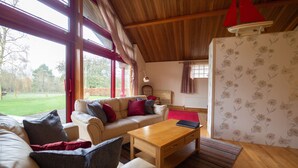 Ein gemütliches Wohnzimmer mit einer Couch, einem Holztisch und einer roten Lampe.