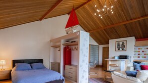 Ein Schlafzimmer mit Bett, Kleiderschrank, Schreibtisch und Stuhl.