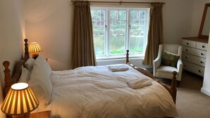A bedroom with a large bed, two bedside lamps, a chair, and a dresser. - Riversdale Lodge is set in the heart of Symonds Yat overlooking the River Wye.  (Symonds Yat)