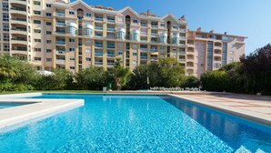 A swimming pool with a view of a multi-story hotel building in the background. - Cascais Park (Cascais)