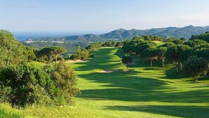 Un campo de golf con vistas despejadas del paisaje circundante y colinas distantes.