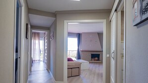 Un pasillo amplio con chimenea empotrada y un reloj en la pared.