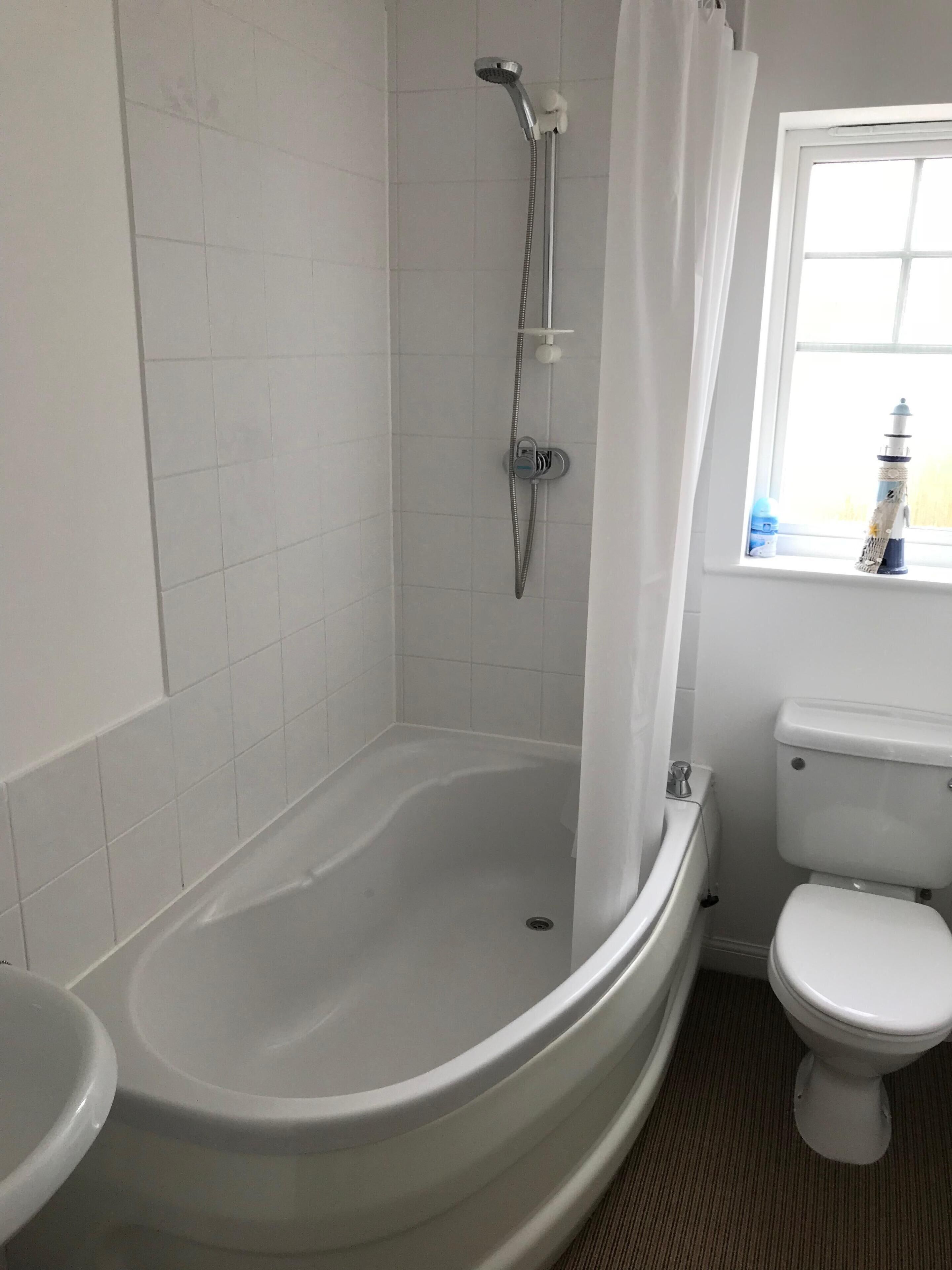 Ein Badezimmer mit Badewanne, Toilette und Dusche.